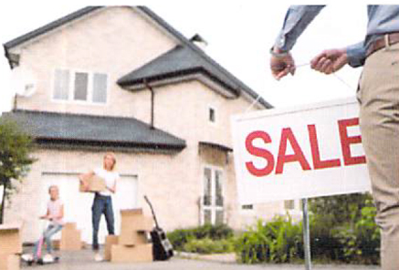 Family in front of a house with a Sale sign